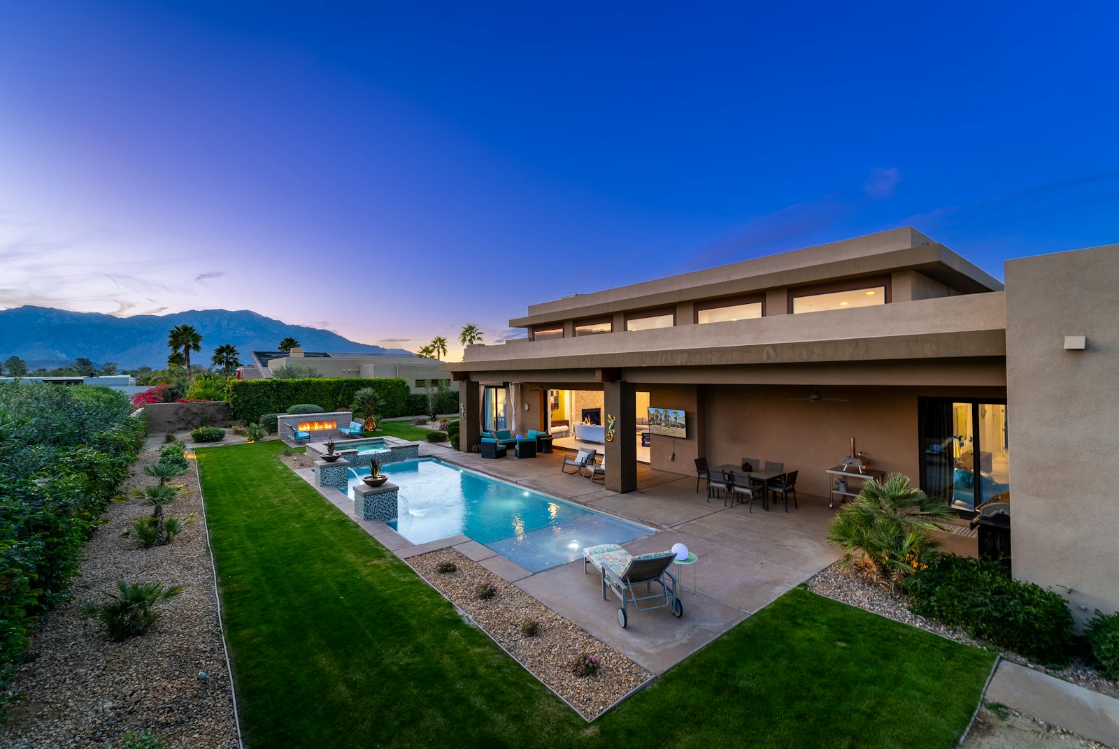 Contemporary home with a backyard pool at sunset